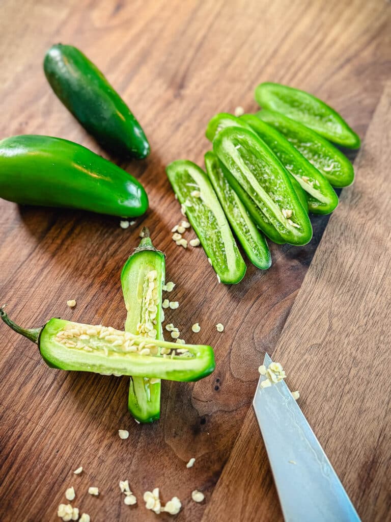 Sliced jalapeños on a cutting board