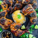 Chicken Inasal on a platter with limes and cilantro