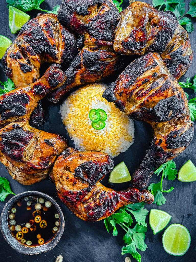 Chicken Inasal on a platter with limes and cilantro