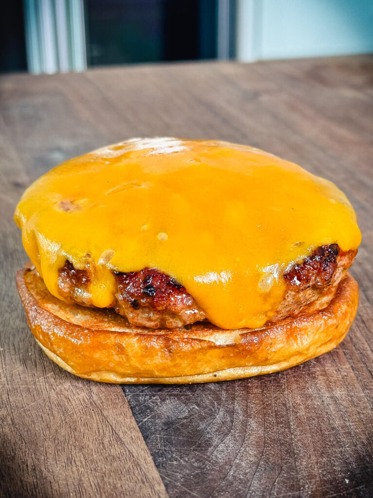 pork patty on a toasted pretzel bun
