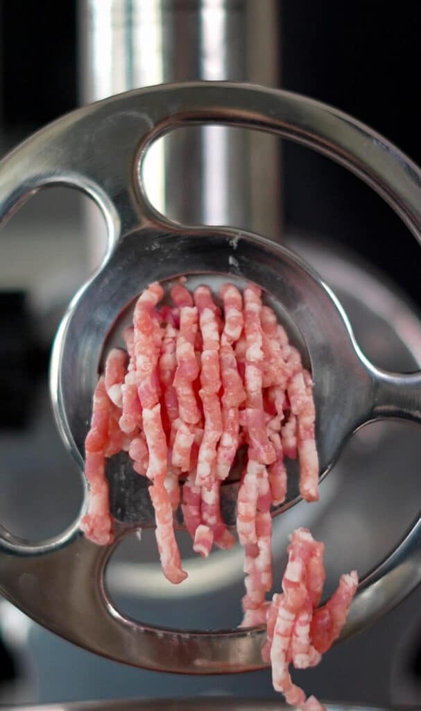 ground pork coming out of a grinder