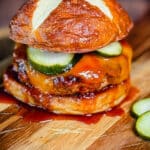 smoked BBQ pork burger with cheddar cheese on a wood cutting board