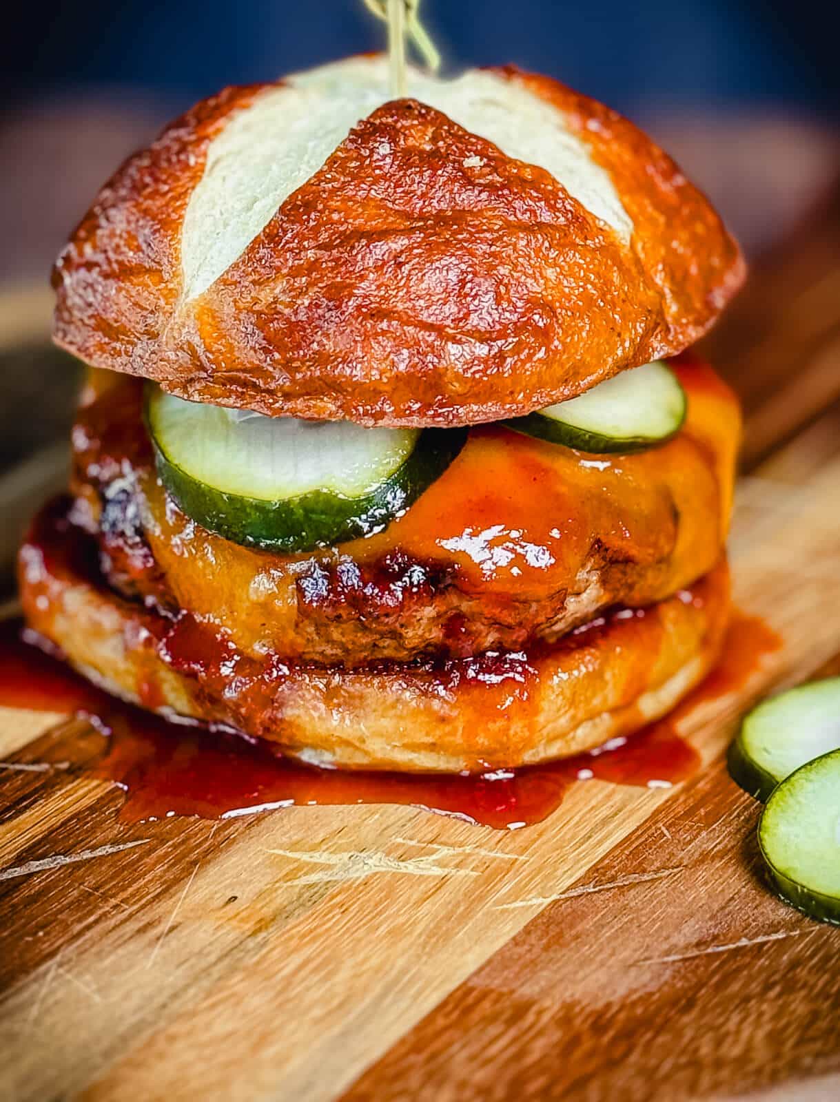 smoked BBQ pork burger with cheddar cheese on a wood cutting board