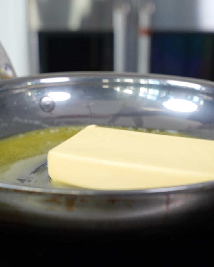 block of butter in a stainless steel pan