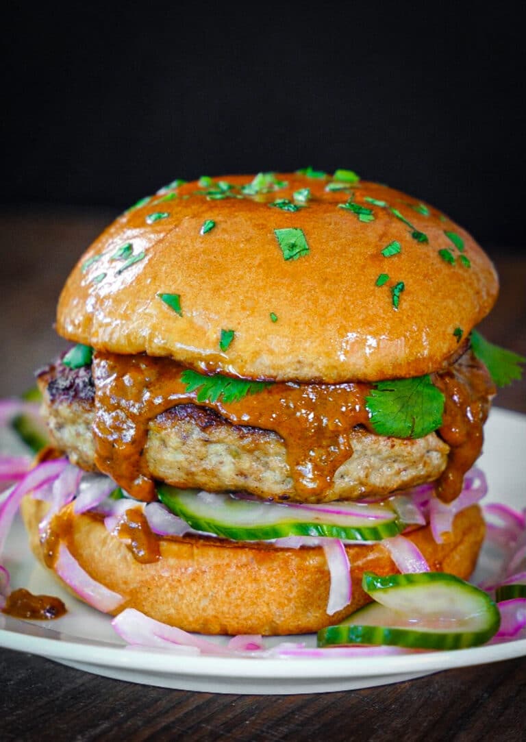 Indian butter chicken burgers on a white plate