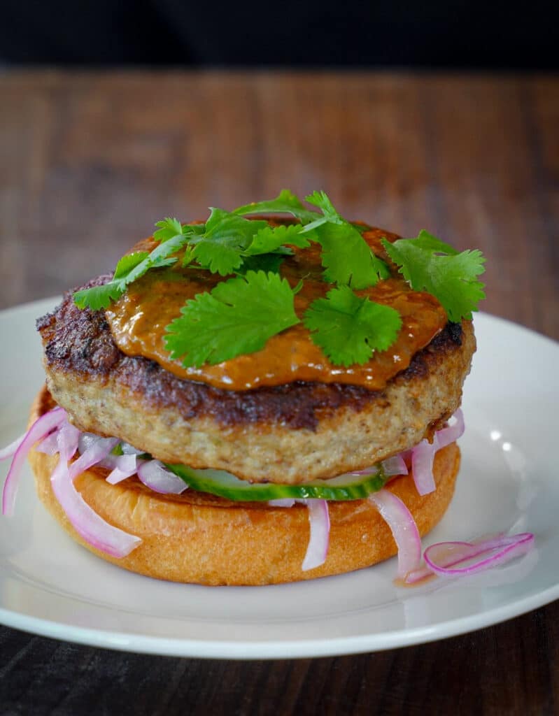 cilantro on top of an indian butter chicken burger