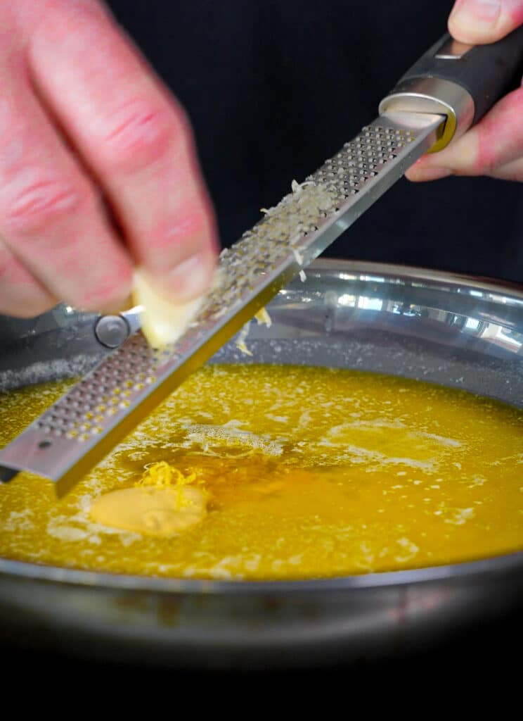 garlic being grated into bandito butter
