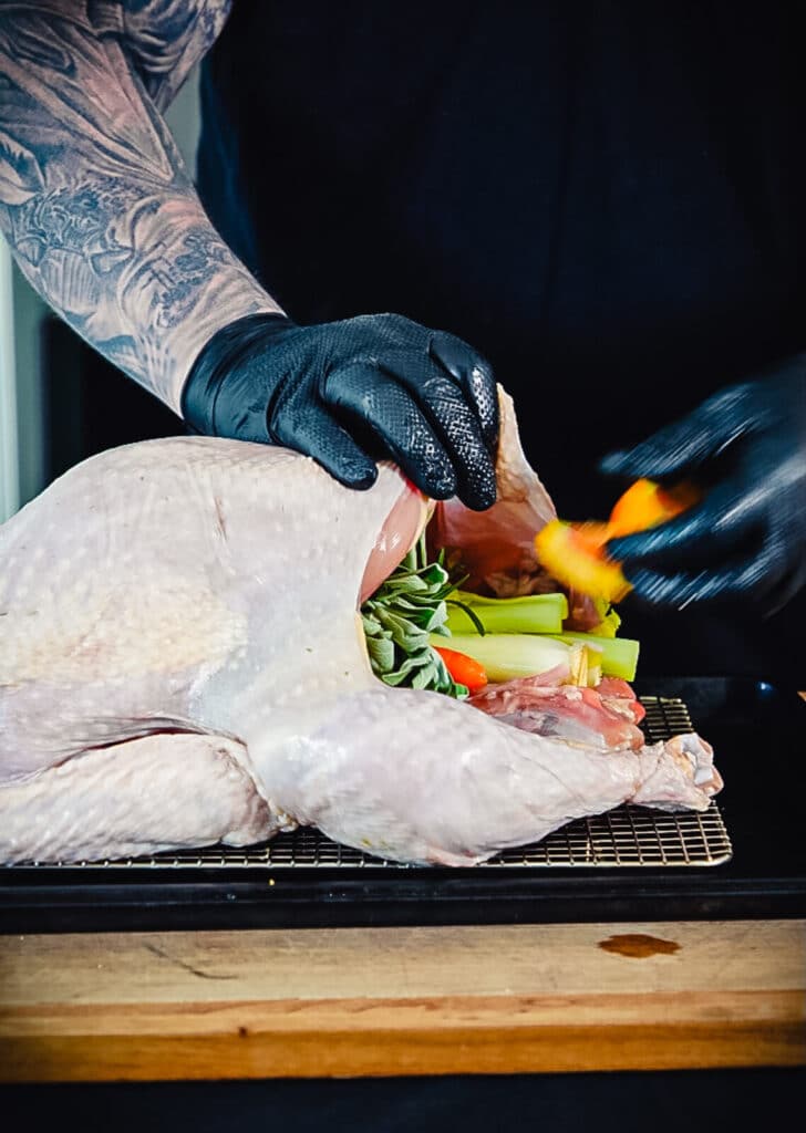 stuffing a smoked turkey with veggies and herbs