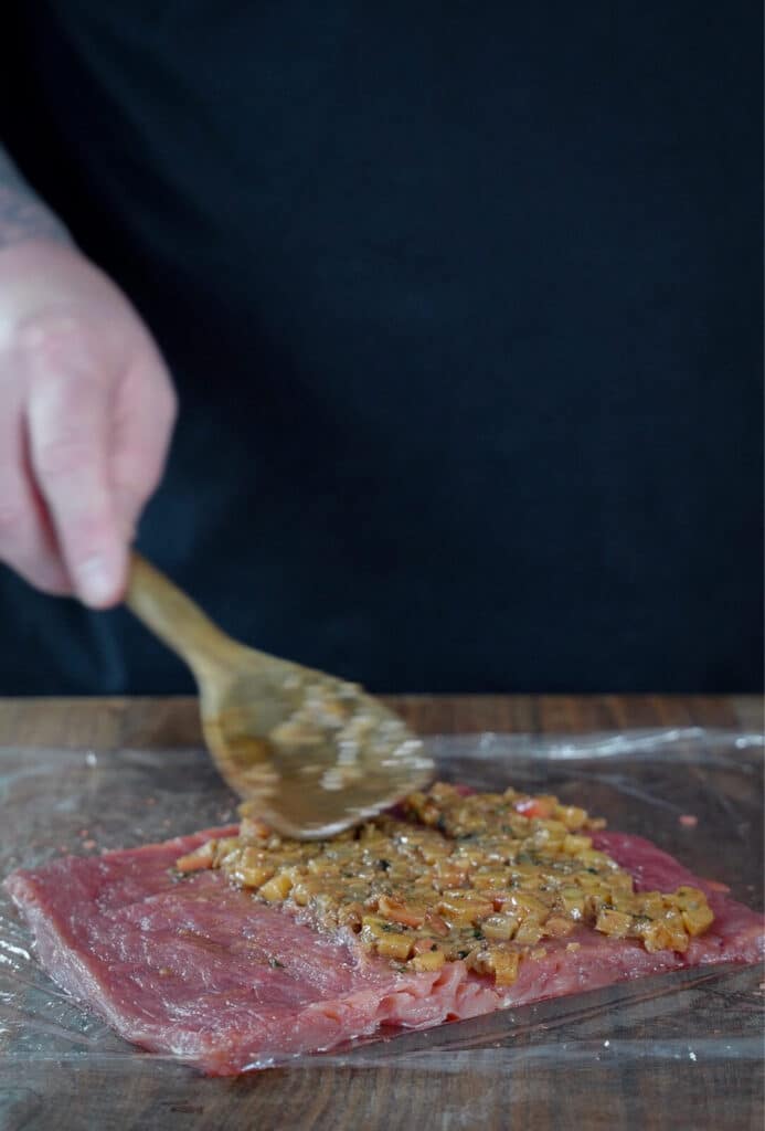 apple and sage filling being added to a pork tenderloin