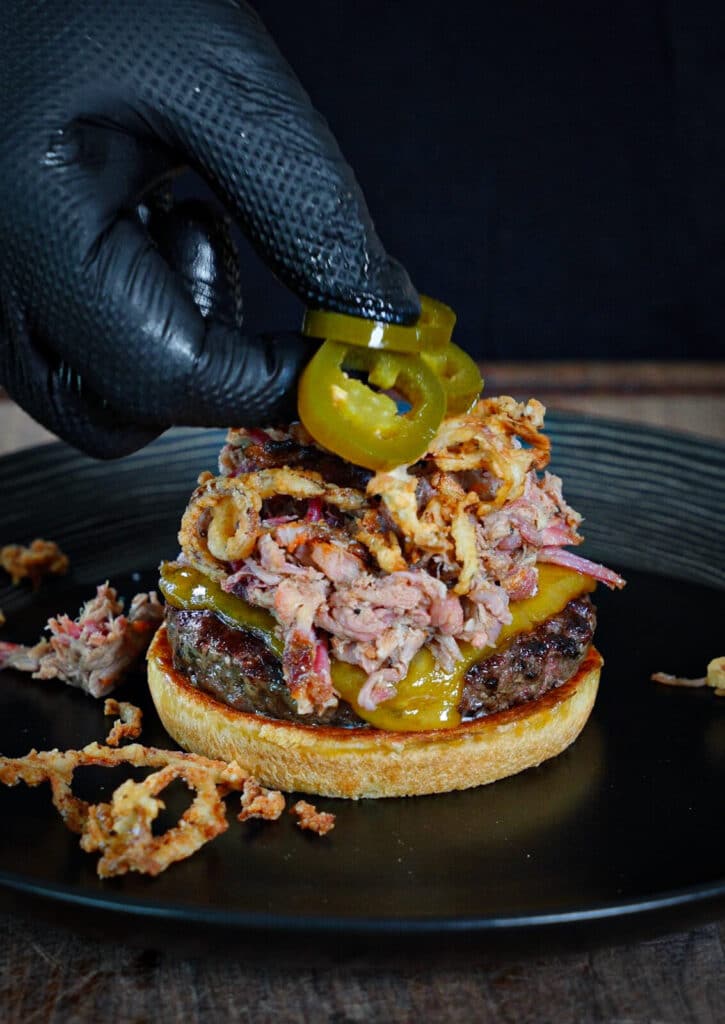 jalapeños being added to a ranch hand burger