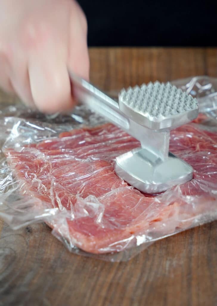 meat hammer flattening out a pork tenderloin