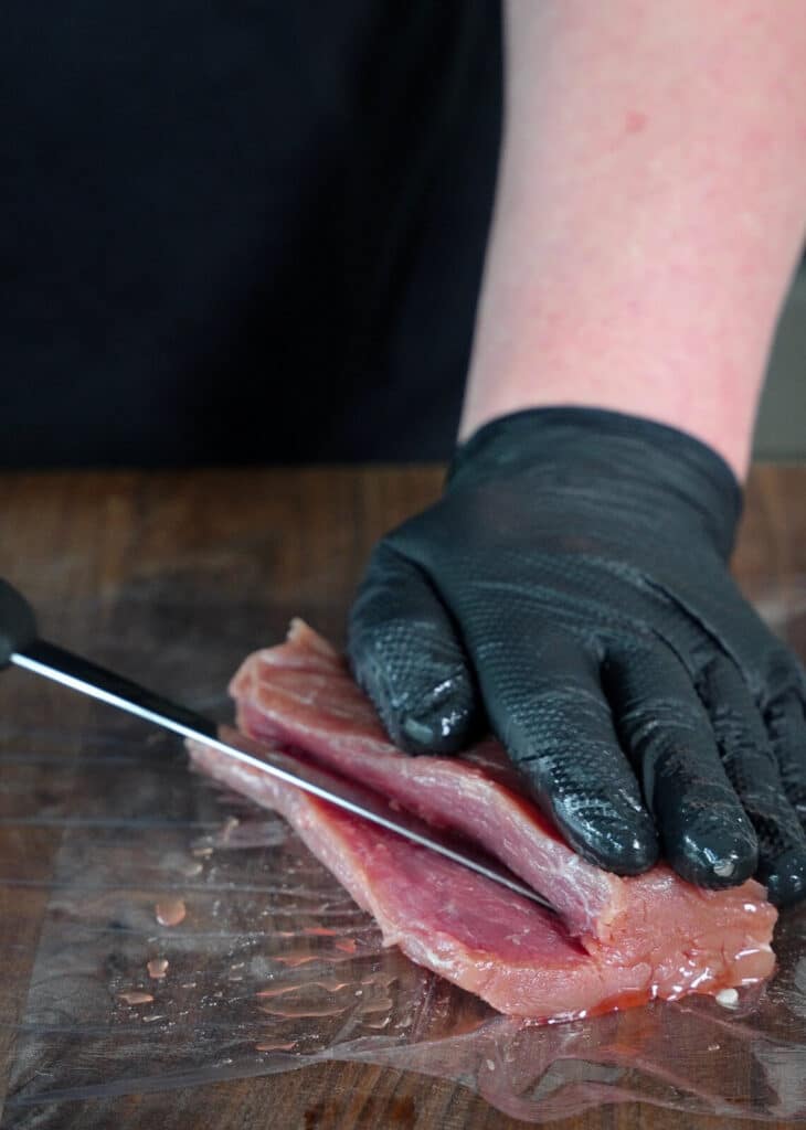 pork tenderloin being sliced open lengthwise