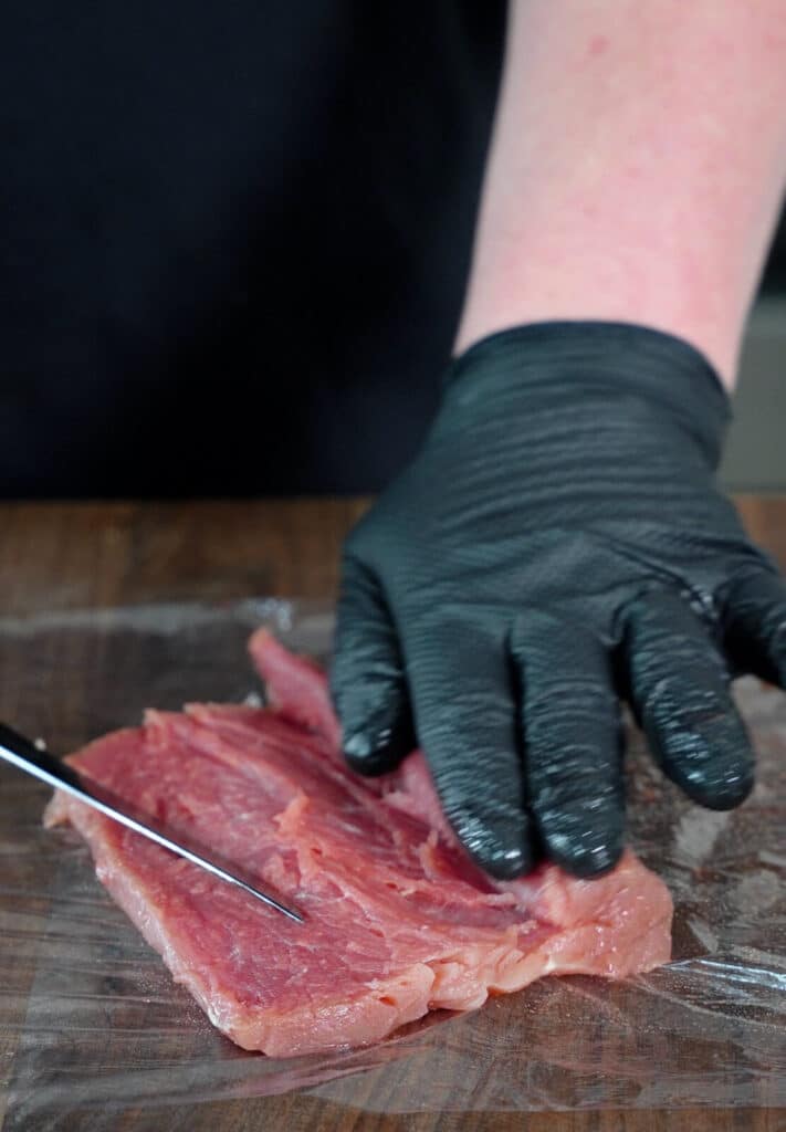 pork tenderloin being sliced open from end to end