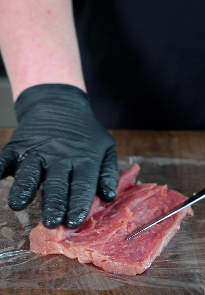 pork tenderloin being buttery cut open on a cutting board