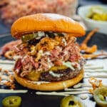 BBQ pulled pork burger on a black plate with jalepano