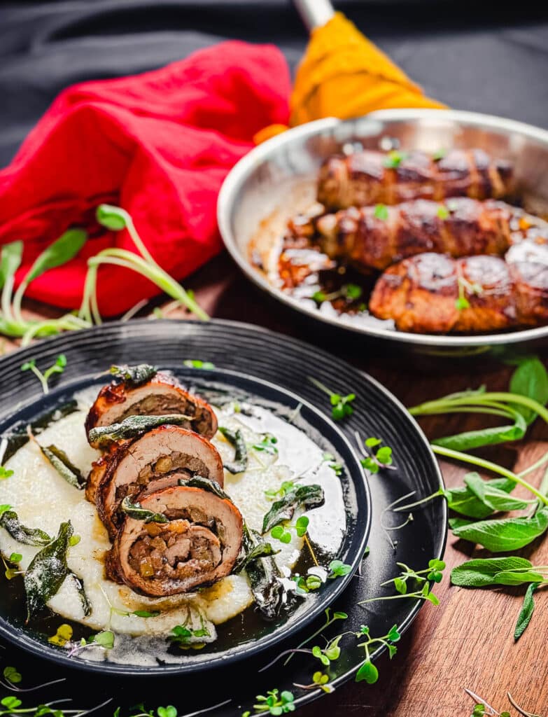 sliced stuffed pork tenderloin on a bed of cheesy grits