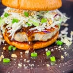 kung pao chicken burger on a bun with sauce