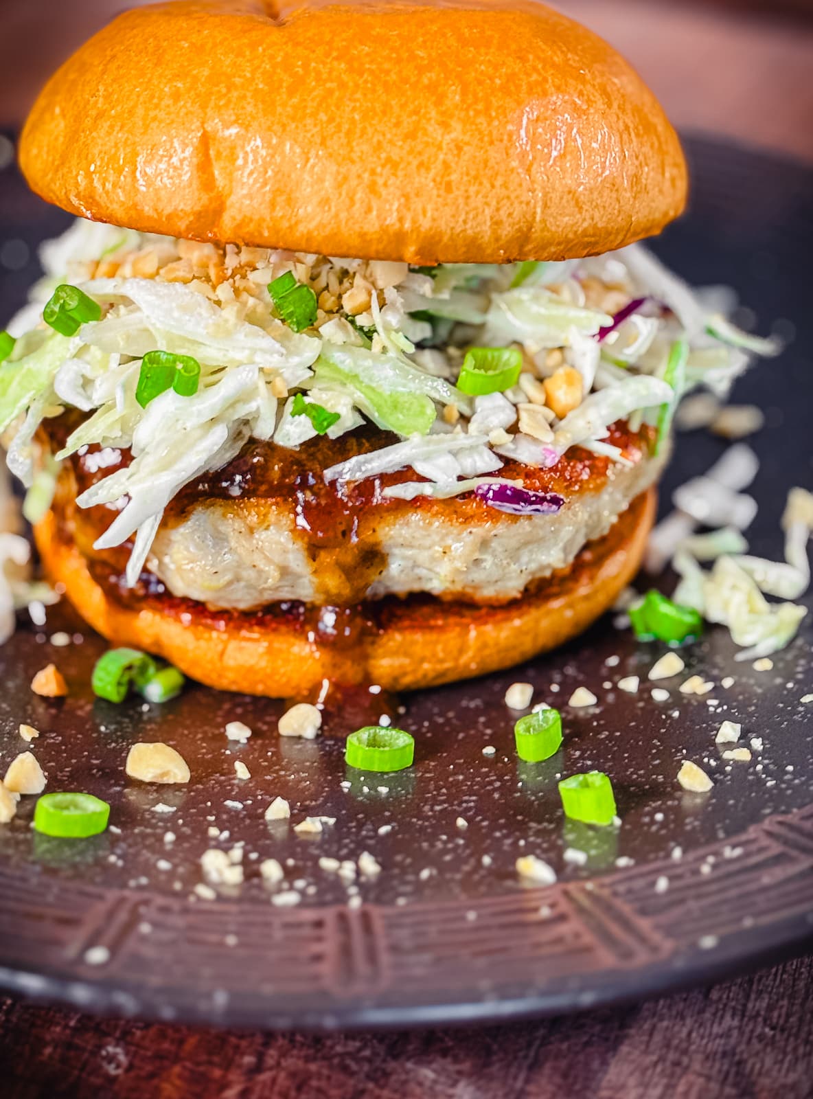 kung pao chicken burger on a bun with sauce