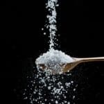 salt being dropped onto a spoon and overflowing