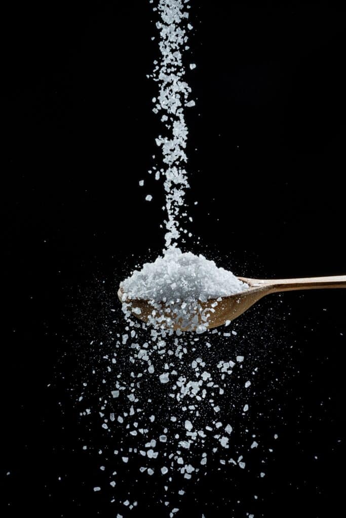 salt being dropped onto a spoon and overflowing
