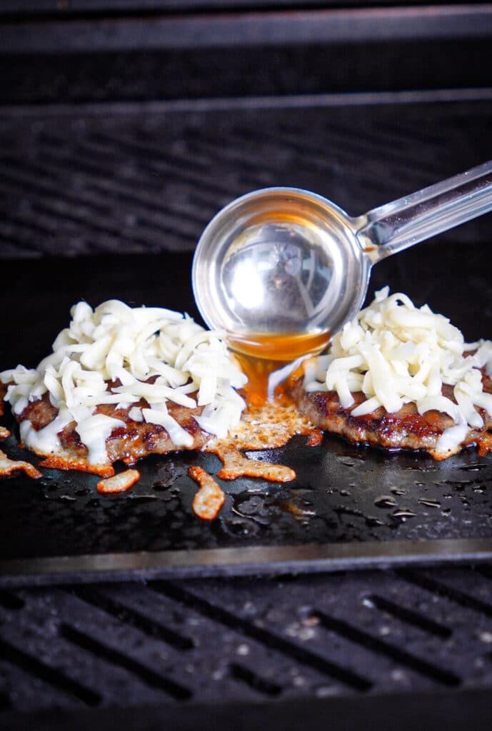 birria consomme being added to a hot griddle 
