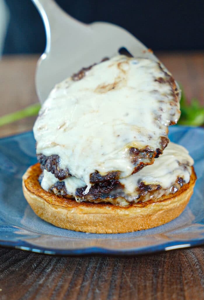 smashburger patty with cheese being added to a bun