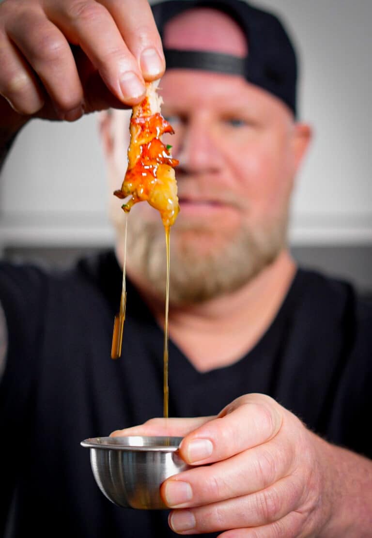 calabrian chili butter dripping off of a piece of lobster meat