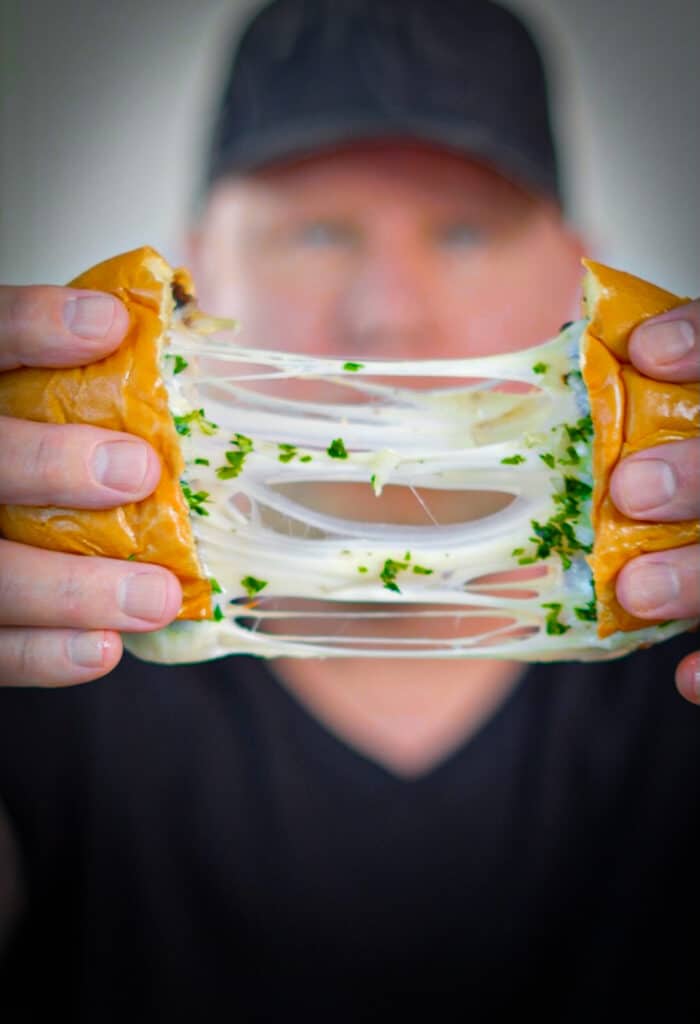 cheese pull from a birria smashburger being pulled apart
