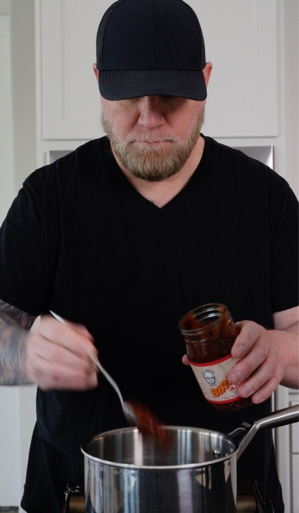 adding birria base to a saucepan