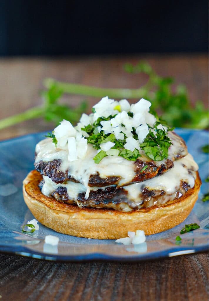 diced white onions added to a birria smashburger