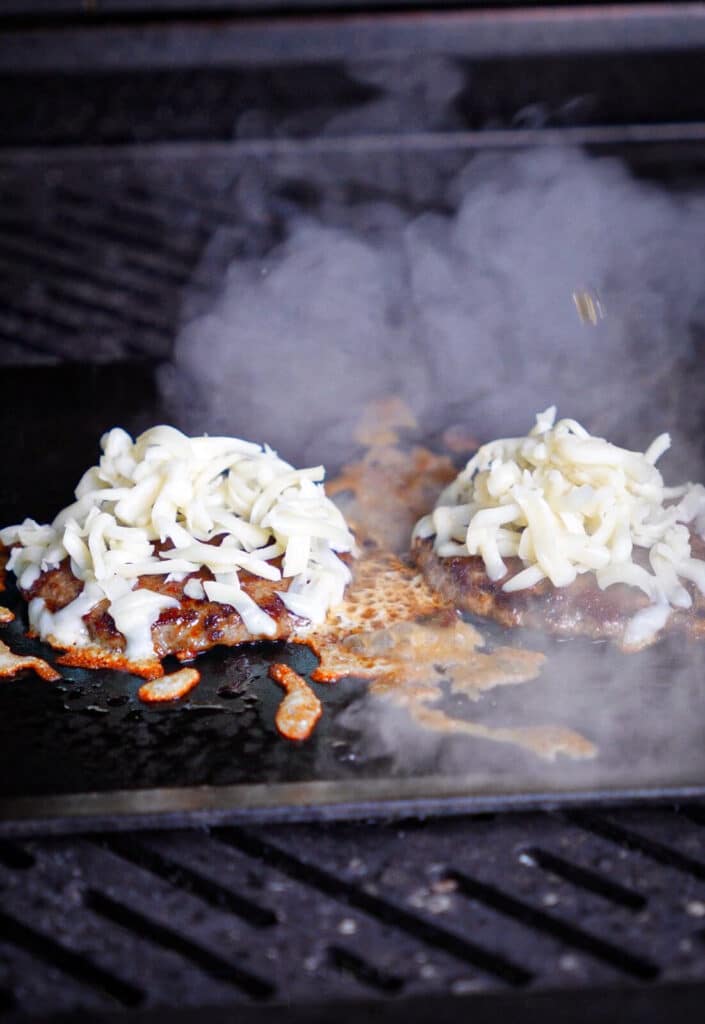 steam forming around birria burgers on a griddle