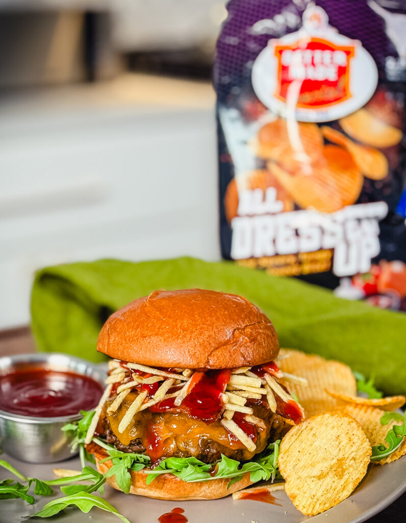 up North Venison Burger on a plate with chips and cherry bbq sauce