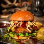 venison burger topped with shoe string potatoes, melted cheddar cheese and cherry bbq sauce