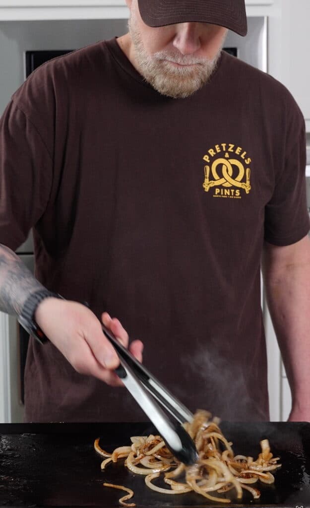 cooking onions down on a griddle surface