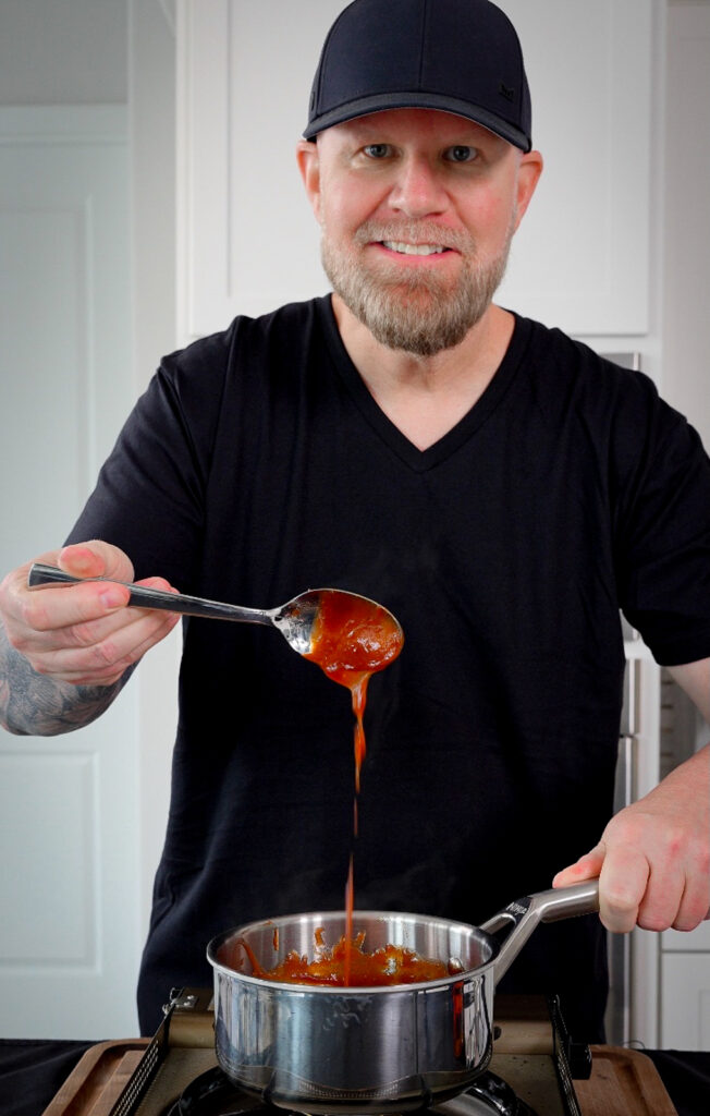 Michigan cherry BBQ sauce dripping from a spoon over a pot
