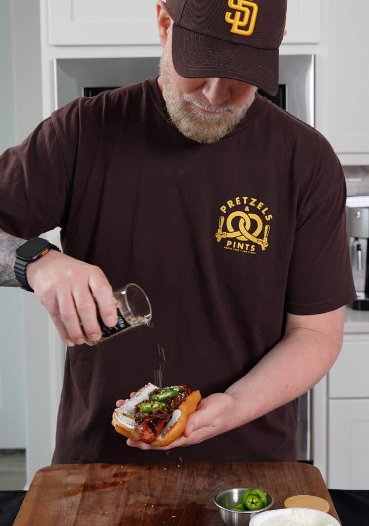 adding everything bagel seasoning to a Seattle style hot dog