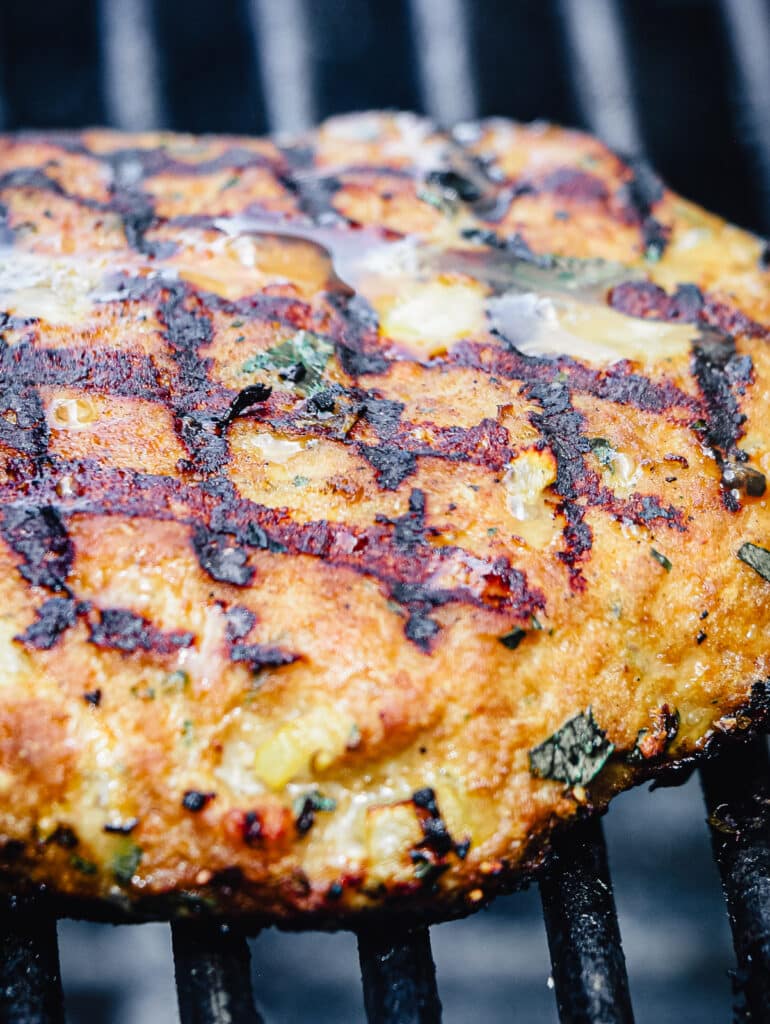 ground chicken burger ona  grill grate over hot coals