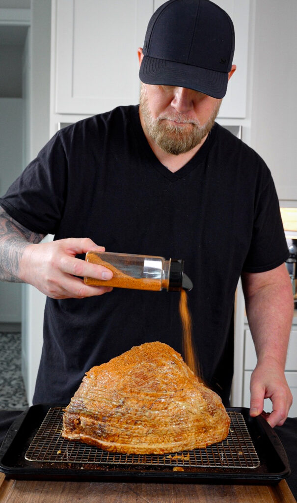 seasoning smoked ham on a wire rack