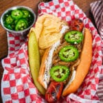 seattle style hot dog in a serving tray with potato chips