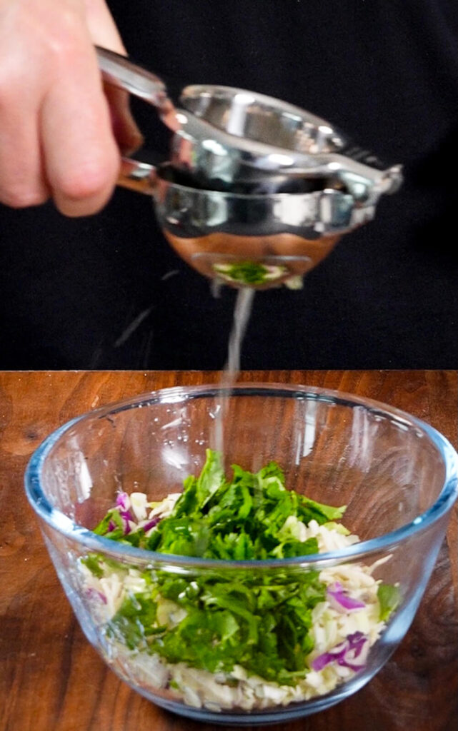 cabbage slaw in a bowl, lime juice being squeezed over it
