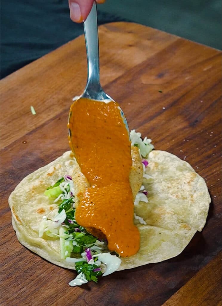 tikka masala sauce being added to a taco