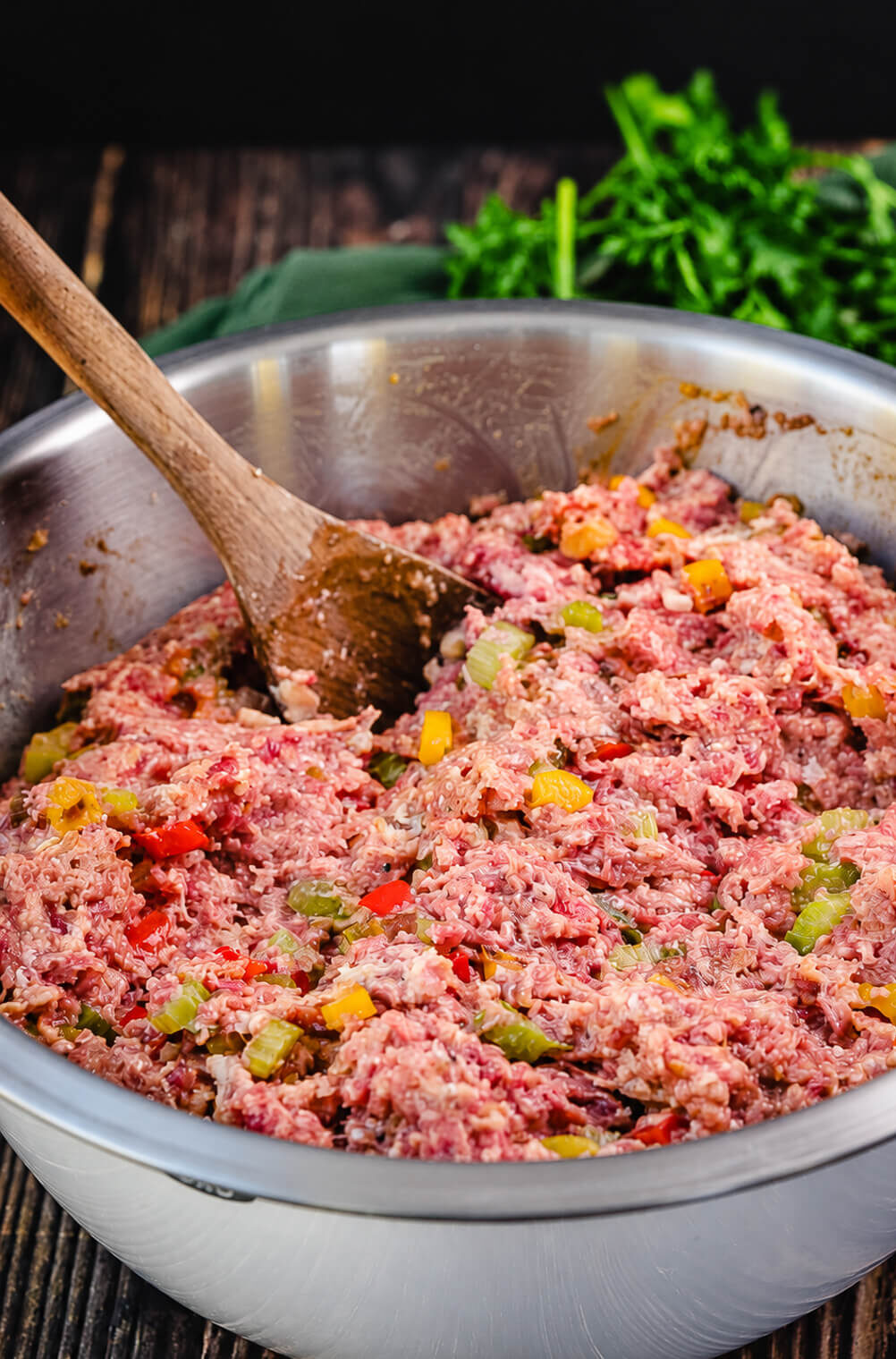 meatloaf mixture in a mixing bowl with a wooden spoon