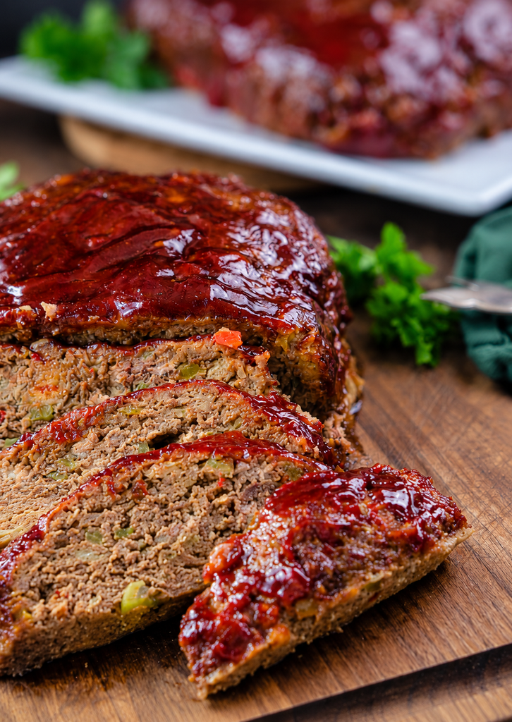 close up slices of meatloaf on a wood cutting board
