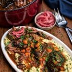 smoked braised short ribs on a platter with mashed potatoes and red onions